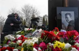  ?? ASSOCIATED PRESS ?? Friends and family of Alexei Navalny comforted each other by his grave in Moscow Sunday after his funeral.