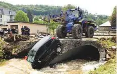  ?? AFP ?? Germany also experience­d heavy rain causing flooding in many towns. Photo shows a car being pulled out of the floods in the city of Herrstein, southern Germany, yesterday.