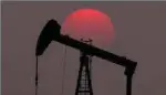  ?? — Reuters ?? The sun sets behind an oil pump outside Saintfiacr­e, near Paris, France.