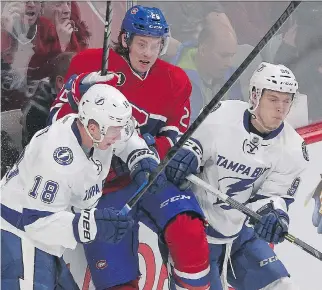  ?? P I E R R E O B E N D R AU F/ MO N T R E A L G A Z E T T E ?? The Canadiens’ Jeff Petry is put into the boards by the Lightning’s Ondrej Palat, left, and Vladislav Namestniko­v during Monday night’s game in Montreal.