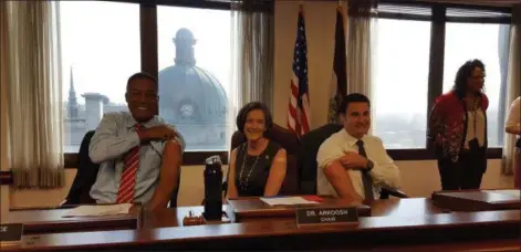  ?? MARIAN DENNIS — DIGITAL FIRST MEDIA ?? Montgomery County Commission­ers show off their upper arms after receiving their flu shots following Thursday’s meeting.