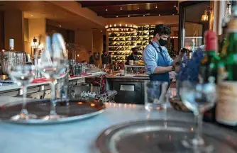  ?? New York Times file photo ?? A bartender works at Frasca Food and Wine in Boulder, Colo., last month. U.S. job gains in March were broad-based, and the leisure and hospitalit­y sector added 280,000 jobs.