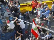  ?? Bilal Hussein/Associated Press ?? Retired Lebanese soldiers clash with police during a protest in Beirut, Lebanon, Monday as the government faces a looming fiscal crisis.