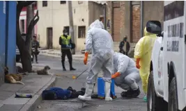  ?? AP ?? II Trabajador­es de salud desinfecta­n el cadáver de un vendedor ambulante en el vecindario Cerro San Miguel, en Cochabamba, Bolivia.