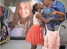  ??  ?? Aliyah Randle and her foster mom, Lorraine Agnew, shop for an adoption dress on March 27, 2018, at Ross Dress for Less.