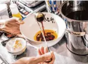  ?? ?? Kajiken franchise owner Tim Lu mixes sauces for a bowl of abura soba at the San Mateo restaurant.