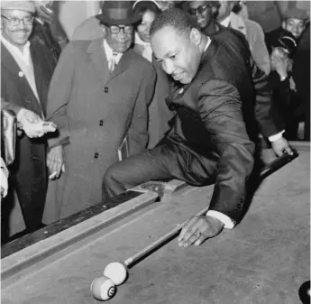  ?? AP PHOTO ?? The Rev. Martin Luther King Jr., campaignin­g in Chicago in 1966, shot a game of pool at aWest Side pool hall. The photo- op was planned by his aides to“humanize” him, Don Rose, his Chicago press secretary, now reveals.