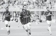  ?? ANTONIO CALANNI
THE ASSOCIATED PRESS ?? AC Milan's Hakan Calhanoglu, centre, celebrates with his teammates after scoring a goal on Saturday against Hellas Verona.