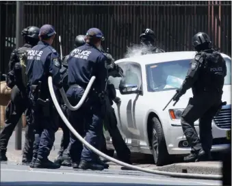  ?? PICTURE: REUTERS ?? SWOOP: Heavily armed police officers prepare to drag a man from his car outside the New South Wales state parliament building in Sydney yesterday. The standoff between a man in the white car and police lasted around two hours, with police fearing the...