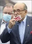  ??  ?? Jacqueline Larma / Associated
Press Former New York Mayor Rudy Giuliani lowers his face mask as he approaches supporters of President Donald Trump on Oct. 12. The city’s GOP members no longer represent the moderate group that pushed Giuliani to victory.