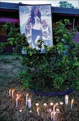  ?? RICHARD GRAULICH / THE PALM BEACH POST ?? Friends and family light candles Wednesday during a vigil honoring the memory of Norriesha Hills (pictured with her sons Errion Brown, 5, left, and Nartavious Hill, 6), slain Monday night in Riviera Beach.