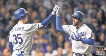  ?? DENNIS WIERZBICKI, USA TODAY SPORTS ?? The Dodgers’ Chris Taylor celebrates with Cody Bellinger after hitting a solo home run against the Cubs on Tuesday night in Chicago.