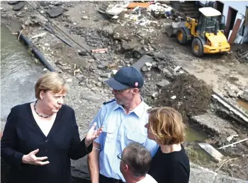  ?? — AFP photo ?? Merkel (left) and Rhineland-Palatinate State Premier Malu Dreyer (right) stand on a bridge overlookin­g the floodravag­ed village of Schuld near Bad Neuenahr-Ahrweiler, Rhineland-Palatinate state, western Germany,