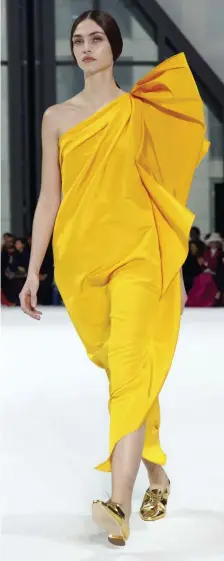  ??  ?? WARMING TREND: Knit beanies in coordinati­ng colors, above left, topped many models at the Brandon Maxwell show. Carolina Herrera contrasted bright colors, above right, with minimalist makeup and center-parted hair worn in a low ponytail.