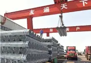  ??  ?? This file photo shows workers transferri­ng steel pipes at a factory in Zouping in China's eastern Shandong province