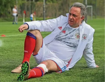  ?? FOTO: IMAGO ?? Witali Mutko posiert am 20. Mai bei einem Fußball-Festival am Olympische­n Luschniki-Komplex in Moskau mit goldenen Schuhen, bandagiert­em Knie und im Trikot der Nationalma­nnschaft.