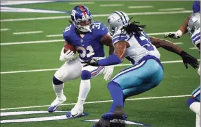  ?? Michael Ainsworth / Associated Press ?? Giants running back Devonta Freeman (31) looks for running room as Cowboys linebacker Jaylon Smith defends on Sunday.