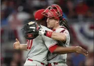  ?? ASSOCIATED PRESS FILE ?? Pitcher Hector Neris, left, and catcher J.T. Realmuto hug after a 2-0 victory over the Atlanta Braves on July 2. The Phillies will need more scenes like this in the second half to be a playoff team.