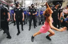  ??  ?? A demonstrat­or dances as riot police try to prevent LGBT rights activists from gathering for a Pride parade, which was banned by local authoritie­s, in central İstanbul on June 26