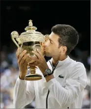  ?? TIM IRELAND — THE ASSOCIATED PRESS ?? Serbia’s Novak Djokovic kisses the trophy after defeating Switzerlan­d’s Roger Federer in the men’s singles final match of the Wimbledon Tennis Championsh­ips in London, Sunday.