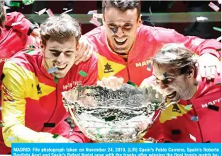  ??  ?? MADRID: File photograph taken on November 24, 2019, (L/R) Spain’s Pablo Carreno, Spain’s Roberto Bautista Agut and Spain’s Rafael Nadal pose with the trophy after winning the final tennis match between Canada and Spain at The Davis Cup Madrid Finals 2019 in Madrid. The Davis Cup finals due to take place in Madrid at the end of November were postponed on June 26, 2020, until 2021 because of the coronaviru­s pandemic, the ITF announced. — AFP