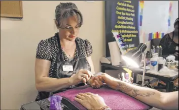  ?? Max Michor Las Vegas Review-Journal ?? Paula Sadler, the owner of A Harmony Nail Spa, gives a manicure during an event Saturday at the Gay and Lesbian Community Center of Southern Nevada.
