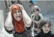  ?? THE ASSOCIATED PRESS ?? A woman screams while fleeing with her family through a destroyed alley as Iraqi Special Forces continue their advance against Islamic State militants in the Old City of Mosul, Iraq, on Sunday