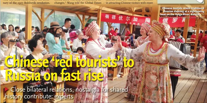  ??  ?? Chinese tourists watch traditiona­l Russian dancing at a sightseein­g boat on the Volga River, Russia.