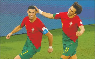  ?? ODD ANDERSEN / AFP VIA GETTY IMAGES ?? Portugal forward Cristiano Ronaldo, left, celebrates with forward Joao Felix after scoring his team’s first goal during the Qatar 2022 World Cup Group H football match.