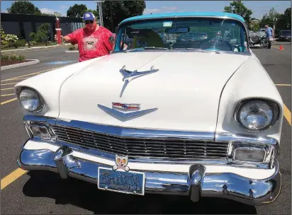  ?? Ernest A. Brown photo ?? Dave Carlson, of Webster, Mass., shows off his trophy he won for his 1956 Sports Coupe 210 at the R1 Indoor Karting All-Makes Super Car Show in Lincoln Saturday.