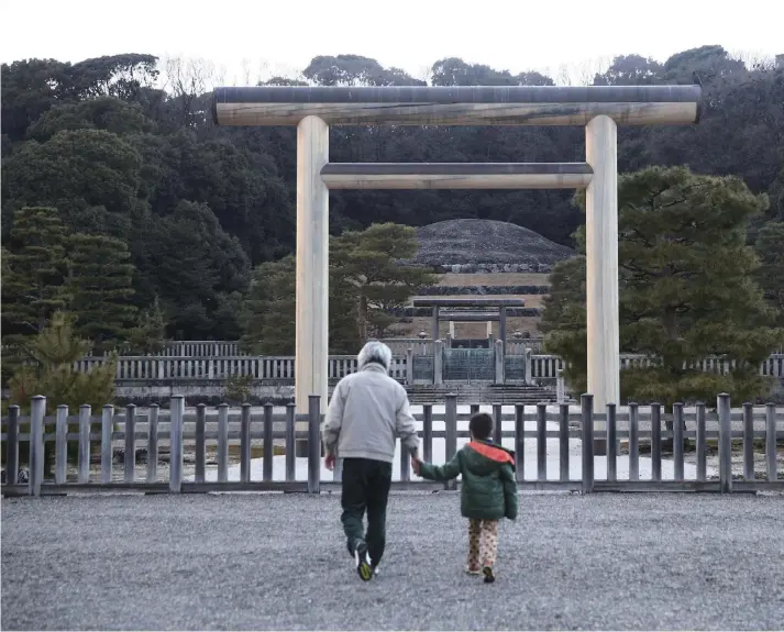  ?? Yomiuri Shimbun photos ?? People walk toward the Momoyama Goryo mausoleum in Kyoto, the tomb of Emperor Meiji built on the site of the former keep of Fushimi Castle.