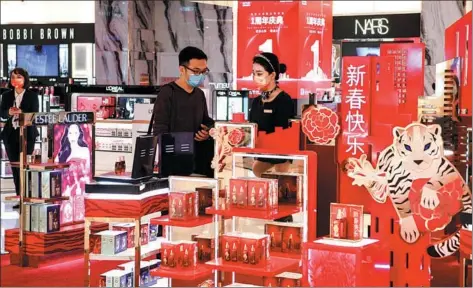  ?? SU BIKUN / FOR CHINA DAILY ?? A shopper buys duty-free goods at a store in Haikou, Hainan province, in January.