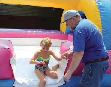  ??  ?? ABOVE: Marisa Schonder exits the water slide with help from John Franclemon­t during Second Avenue United Methodist’s water day. The water day was a celebratio­n for the final day of their Smart Kids, Smart Lunch program in which the church served...