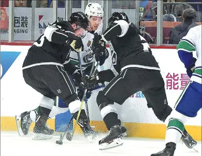  ?? PROVIDED TO CHINA DAILY ?? Vancouver Canucks forward Brandon Sutter battles a pair of Los Angeles Kings defenders for puck possession during Thursday’s NHL China Games showdown at Mercedes-Benz Arena in Shanghai. The Kings won 5-2, with a rematch set for Saturday afternoon at...