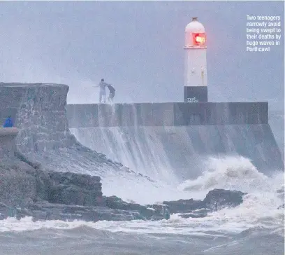  ??  ?? Two teenagers narrowly avoid being swept to their deaths by huge waves in Porthcawl