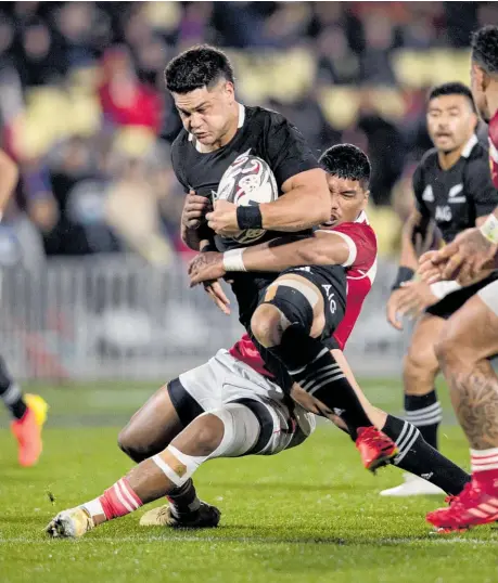  ??  ?? All Blacks midfield rookie Quinn Tupaea attempts to break the Tonga defence last night at Mt Smart Stadium.