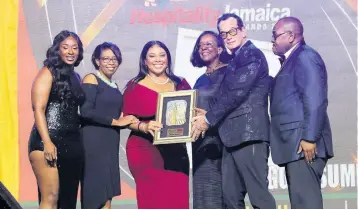 ?? PHOTO BY ASHLEY ANGUIN ?? Chief judge for the RJRGLEANER Hospitalit­y Jamaica Awards, Marcia Erskine of Marcia Erskine and Associates (third right), presents the Best Event of the Year Award to the Joe Bogdanovic­h-led (second right) Downsound Entertainm­ent team.