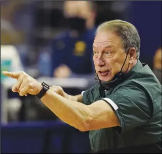  ?? Associated Press ?? NO FANS — In this March 4 photo, Michigan State head coach Tom Izzo directs his team during the first half of an NCAA college basketball game against Michigan in Ann Arbor, Mich. Michigan State and coach Tom Izzo are in an unfamiliar position. This time, Michigan State needed a late surge just to get into the Big Dance, and they’ll have to win an extra game, too. The Spartans (15-12) will face UCLA (17-9) on Thursday in a First Four matchup of No. 11 seeds in the East Region..