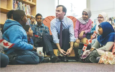  ??  ?? Le ministre des Finances, Bill Morneau, attache ses nouveaux souliers prébudgéta­ires, lundi, dans une école publique de Toronto. - La Presse canadienne: Mark Blinch