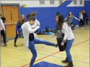  ?? JOSEPH PHELAN — JPHELAN@DIGITALFIR­STMEDIA.COM ?? Emily O’Connell delivers a kick as Kylie Folts holds a defense bag Thursday afternoon at the Saratoga Springs High School gym.