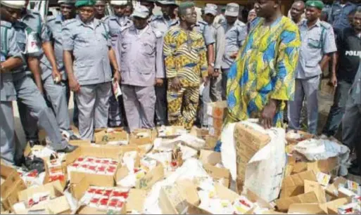  ??  ?? Some customs officials and seized contraband