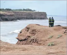  ?? ERIC MCCARTHY/JOURNAL PIONEER ?? Two Tignish firefighte­rs stand near the water’s edge at North Cape looking for any sign of the two fishermen who went missing after their boat sank on Sept. 18. The bodies of captain Glen DesRoches and Moe Getson were recovered in the following days.