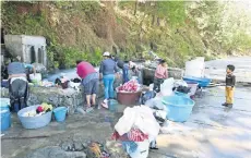  ??  ?? Las mujeres usan bases de cemento elaboradas por los hombres para hacer sus tareas; la mayoría de ellas son acompañada­s por sus hijos.