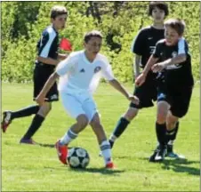  ??  ?? Thomas Muzekari with the ball for FC Patriots U13 Red (in white), who captured both an outdoor state cup and an EDP Regional trophy.