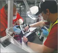  ?? (AP/Carlos Osorio) ?? Ford Motor Co. employees work on a ventilator at the Rawsonvill­e plant in Ypsilanti Township, Mich.