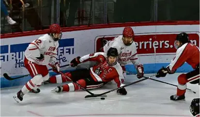  ?? JOSH REYNOLDS FOR THE GLOBE ?? Justin Hryckowian (center) and NU couldn’t find their footing at Agganis Arena on Saturday.