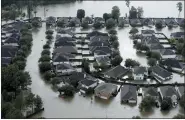  ?? ASSOCIATED PRESS FILE PHOTO ?? Homes are surrounded by floodwater­s from Tropical Storm Harvey in Spring, Texas, on Aug. 29, 2017. Experts say more intense storms driven by climate change are boosting contaminat­ion risks for privately-owned drinking water wells.