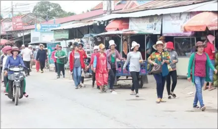  ?? ALEX WILLEMYNS ?? Garment workers walk along a street in Kandal’s Svay Rolum commune during a lunch break last week. The commune went handily to the opposition in the recent commune elections, unlike some neighbouri­ng areas.