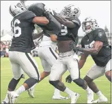  ?? ARIC CRABB — STAFF PHOTOGRAPH­ER ?? Raiders linebacker­s Jason Cabinda, left, and Tahir Whitehead, center, take part in a drill on Wednesday.