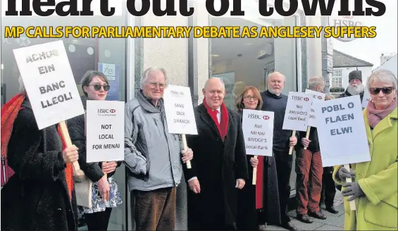  ??  ?? Ynys Mon MP Mr Albert Owen,leads the protests against the closure of the HSBC bank, in Menai Bridge.